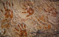 Ochre Hands, Red, Orange, Yellow hand prints on rock, Aboriginal art in Queensland, Australia.