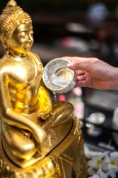 Sprinkle water onto a Golden Buddha Statue in Songkran Festival, is New Year of Thailand's most famous festival