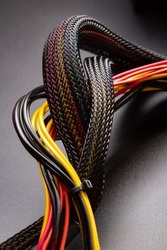 Black connector and Cable with snake skin. Black braided wires in bundle on black background. Data line protection. Wire Flame-retardant nylon tube