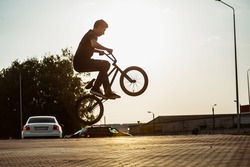 teenager jump on a bicycle outdoors