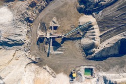 Aerial view of industrial mineral mine from above. Opencast mining quarry with lots of machinery at work. Drone view from above.