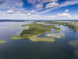 View of small islands on the lake in Masuria and Podlasie district, Poland.
Blue water and whites clouds. Summer time. View from above.