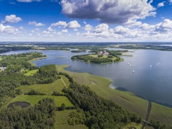 View of small islands on the lake in Masuria and Podlasie district, Poland.
Blue water and whites clouds. Summer time. View from above.