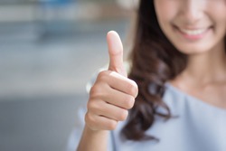 successful girl pointing thumb up; portrait of cheerful smiling woman pointing up approving, yes, ok, good, thumb up gesture; asian woman young adult model