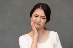 woman with toothache; sick asian woman suffering from toothache, tooth decay, tooth sensitivity, wisdom tooth pain, cavity, dental care concept; young adult asian woman model