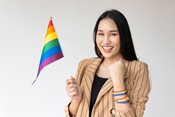 Strong non-binary LGBT person waiving rainbow flag for LGBT awareness pride month