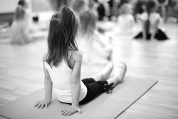 Small girls doing sport exercise sitting on the mat,ballet school;monochrome