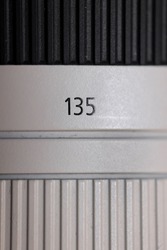 Close up shot of 135mm focal length indicator on Camera lens.