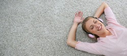 Blond girl relaxing on carpet floor with headphones on, Template