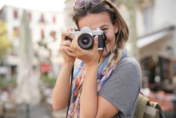 Young woman taking photographs on SLR                              