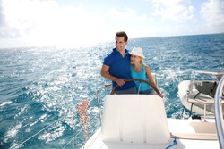 Young couple navigating on a yacht in caribbean sea