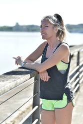 Middle-aged blond woman jogging by the river, citylife