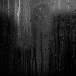 Rainy background with flowing down water drops on window glass