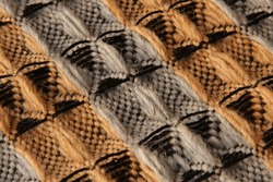 Closeup of threedimensional waffle weave pattern in orange and grey