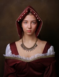 Portrait of a gorgeous girl in medieval time dress and headdress.