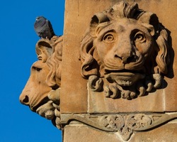 Close-up of the Lion head sculptures on the base of the Sir Walter Scott Monument in George Square, in the city of Glasgow, Scotland, UK.