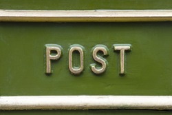 Close-up of the word POST on a traditional Victorian post box in the UK.