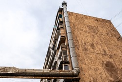 huge vent pipe on wall of multi-storey apartment building in Yerevan city on cloudy autumn day