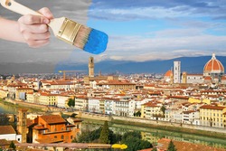 travel concept - hand with paintbrush paints blue sky over Florence city, Italy