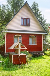 wooden well and simple country cottage in summer day