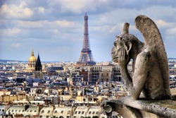 Famous Notre Dame gargoyle overlooking the Paris cityscape with Eiffel Tower 