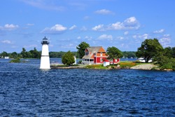 Cottage with lighthouse on one of the Thousand Islands during summer, New York state, USA