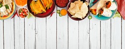 Mexican food top border, Overhead view on a white wood banner background. Quesadilla, tacos, nachos and burritos. Copy space.