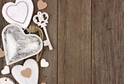 Side border of white and silver hearts and love themed decor on a rustic wooden background