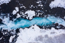 Amazing blue water stream in Iceland in winter. Aerial drone top down view