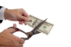 A business man's hands cutting a $20 bill on a white background