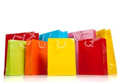 Assorted colored shopping bags including yellow, orange, red, pink, blue and green on a white background