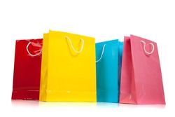 Assorted colored shopping bags including red, yellow, blue and pink on a white background
