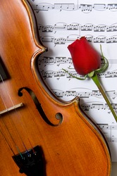 A violin, red rose and sheet music