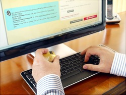 Businessman with credit card using computer for online purchase.