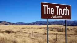 The Truth road sign with blue sky and wilderness