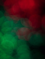abstract defocused round shaped green and red lights on black background