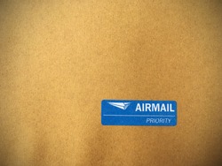 airmail priority sticker on brown paper.