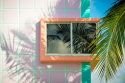 Detail close-up of typical colorful Art Deco architecture with tropical palm tree shadows in South Beach, Miami, Florida