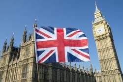 Great British Union Jack flag flying in front of Big Ben and the Houses of Parliament at Westminster Palace, London, a symbol of national pride during the EU Brexit and election proceedings