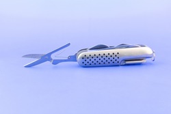 Pocket knife isolated on light blue background