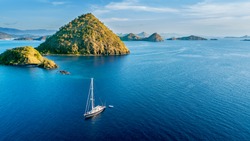 Aerial view of sailboat with island under blue sky in Labuan Bajo near Bali Island, Indonesia