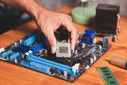 Technician Installing CPU to socket LGA 1155 on motherboard.