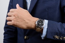 Closeup luxury wristwatch on the wrist of businessman in navy blue suit