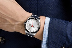 Closeup luxury wristwatch on the wrist of businessman in navy blue suit