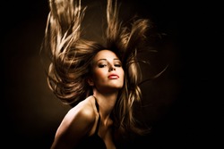 beautiful woman with long golden hair in motion, studio shot