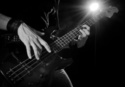 rock concert: bass guitarist playing on stage