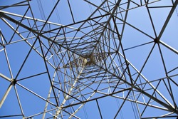 Pylon tower structure viewed from directly below against blue sky