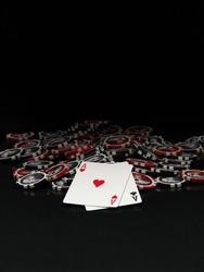 Black and red poker chips and cards isolated on black background