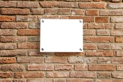 Empty information sign on old brick wall. White color