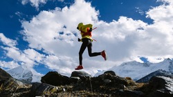 Woman trail runner cross country running in high altitude winter nature